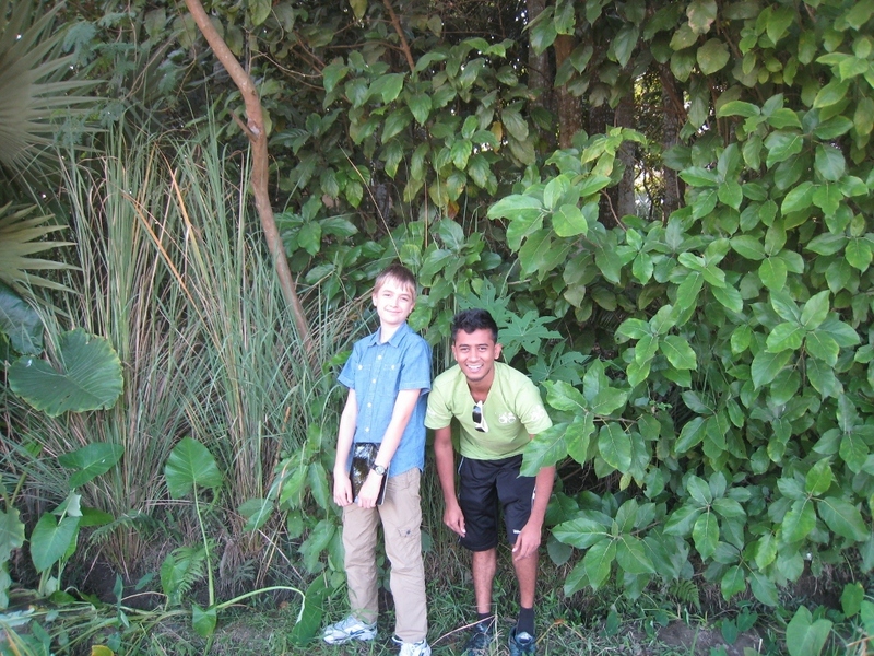 Shuchak and Kevin standing at the row of trees